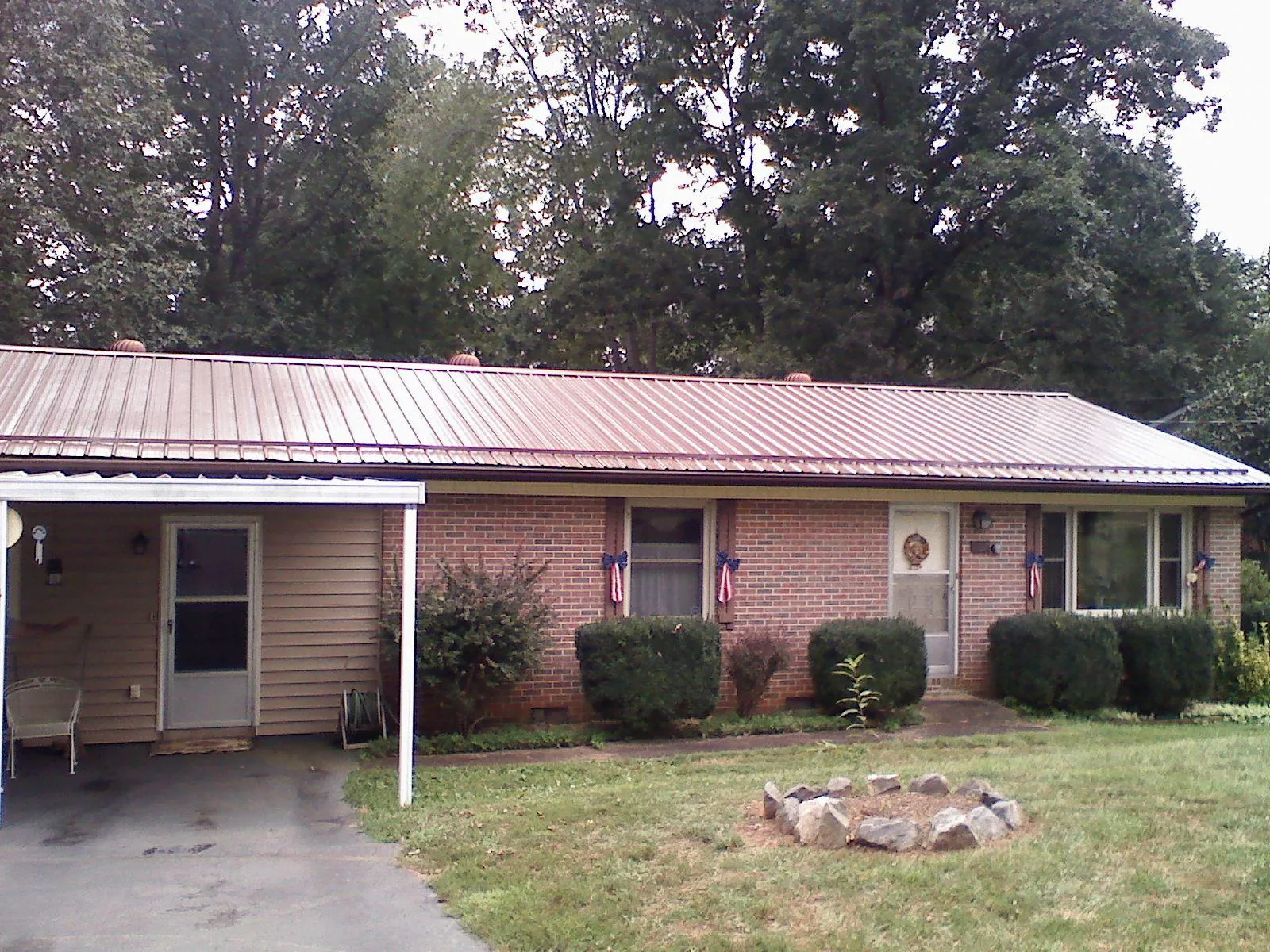 Bronze metal roof and carport on a brick ranch home — Roof Repair work by our crew in Turners Station