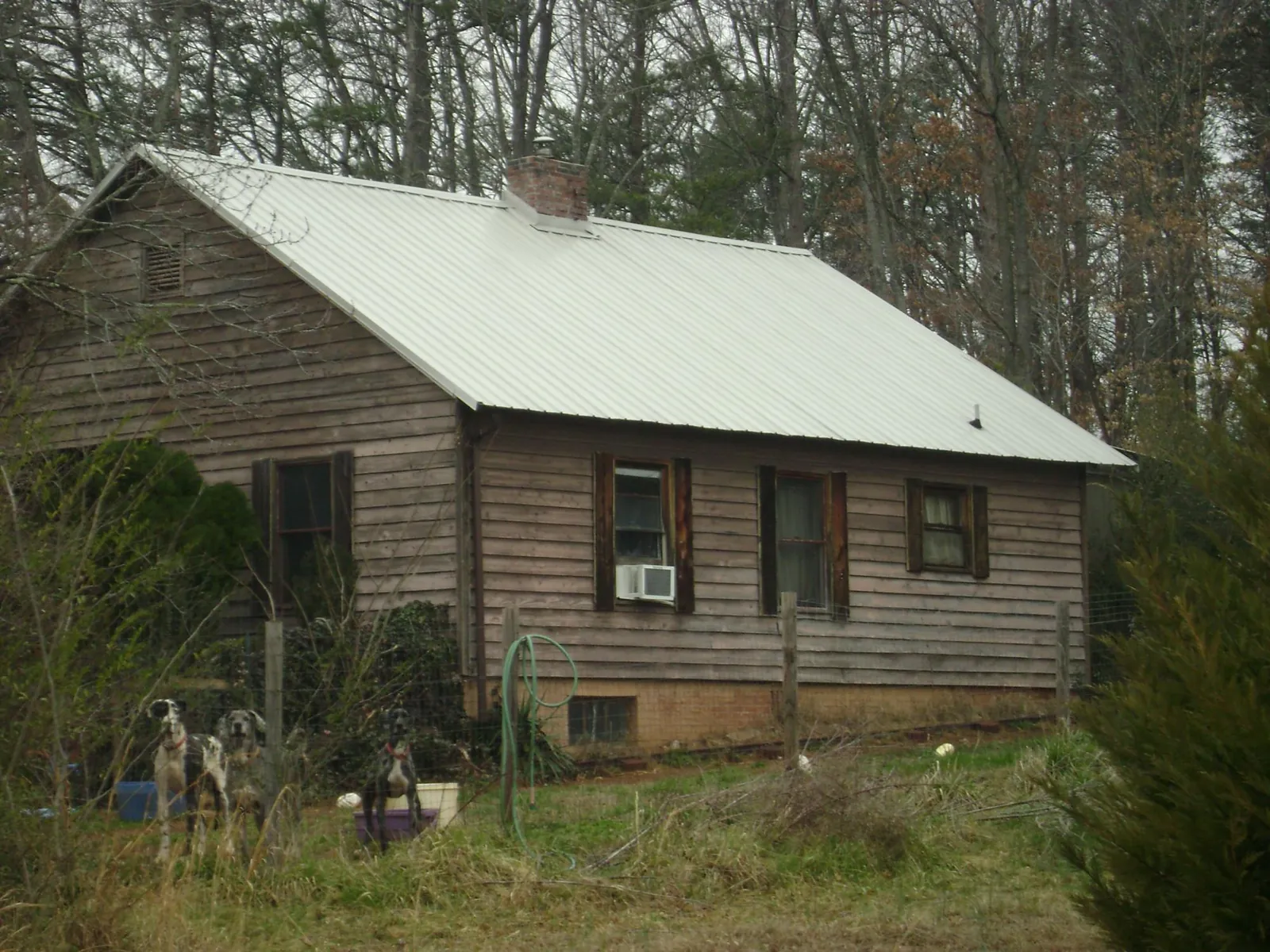 White metal roof on an old wood sided farmhouse, from a Metal Roof Installation job in Turners Station